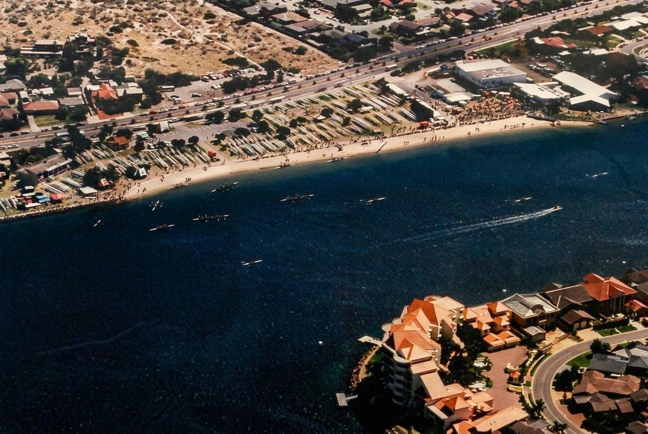 An aerial photograph of crews racing past the boat park and crowds on the West Lakes shore at the 1999 National Rowing Championships